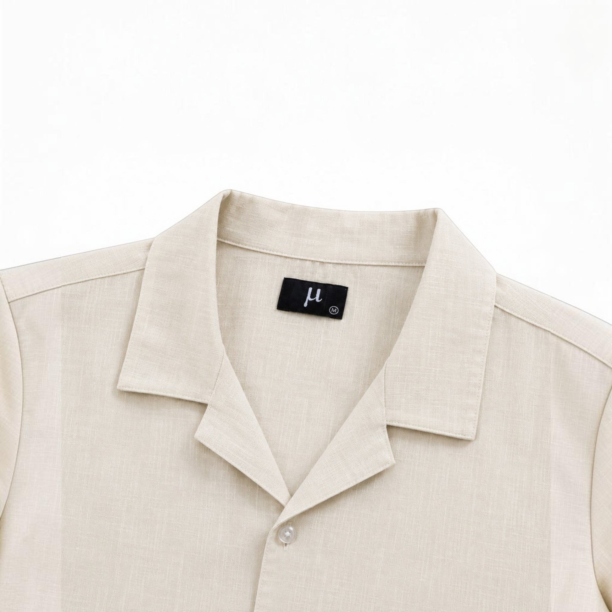 MU SHOP beige linen shirt with a soft structured collar and button closure. Relaxed fit, breathable fabric.