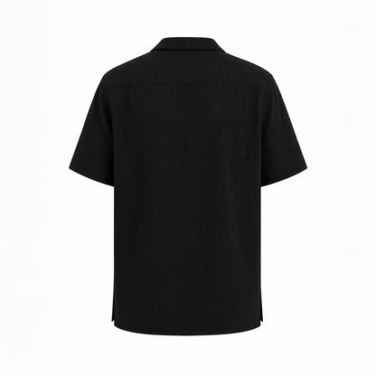 MU SHOP black linen short-sleeve shirt with a soft structured collar and matte buttons. Relaxed fit.
