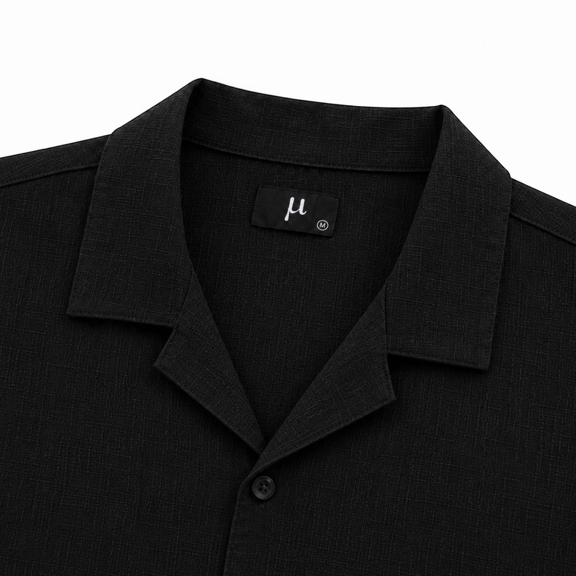 MU SHOP black linen shirt with a soft structured collar and matte button. Relaxed fit, ideal for warm weather.