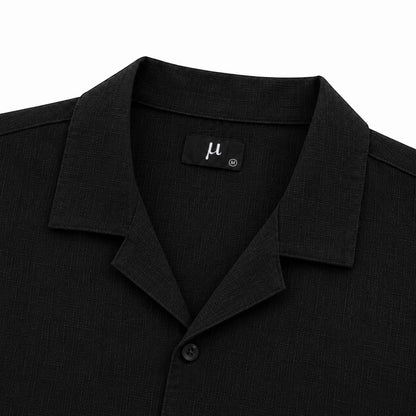 MU SHOP black linen shirt with a soft structured collar and matte button. Relaxed fit, ideal for warm weather.